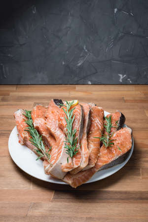 fresh raw red fish fillet on white plate and rosemaryの写真素材