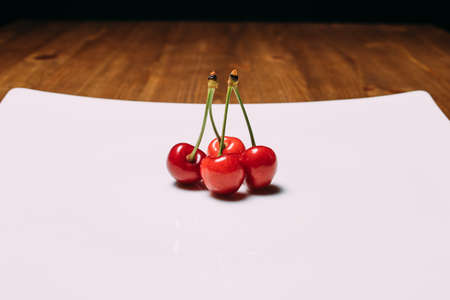 Fresh cherry on plate on wooden blue background. fresh ripe cherries. sweet cherries. Close upの写真素材