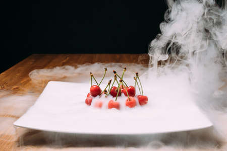 fresh cherry lays on ice on a white plate and soars. close upの写真素材