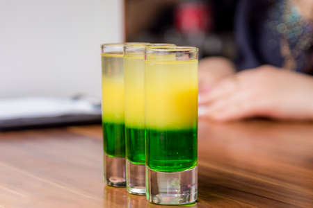 Beautiful tricolor cocktail. three-color cocktail in the bar. close upの写真素材