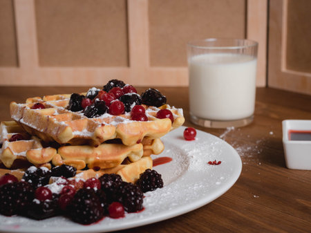Belgian waffles with berries. milk. Syrup. Wooden table. Close upの写真素材