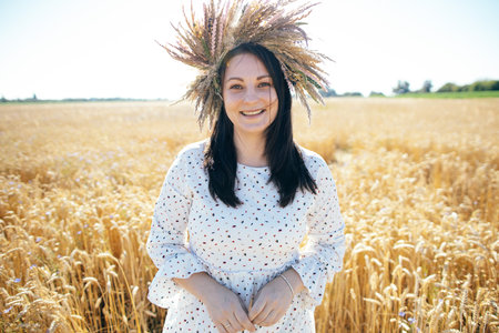 portrait of a young girl in a beautiful dress walking in a wheat fieldの写真素材
