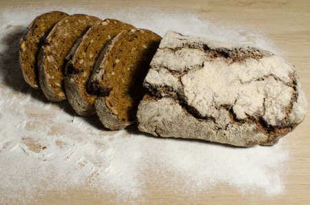 Fresh bread slice and cutting knife on rustic tableの写真素材