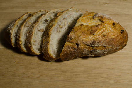 Fresh bread slice and cutting knife on rustic tableの写真素材