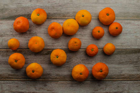 tangerines, peeled tangerine and tangerine slices on a white wooden tableの写真素材