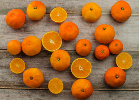 tangerines, peeled tangerine and tangerine slices on a white wooden tableの写真素材