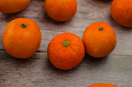 tangerines, peeled tangerine and tangerine slices on a white wooden tableの写真素材