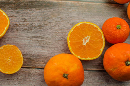 tangerines, peeled tangerine and tangerine slices on a white wooden tableの写真素材