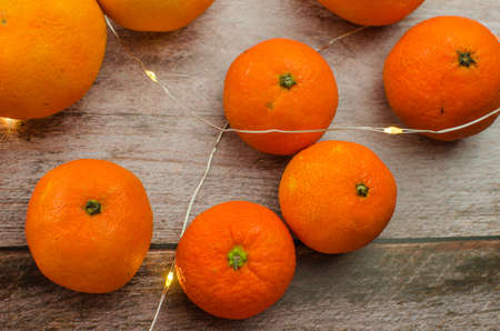 tangerines, peeled tangerine and tangerine slices on a white wooden tableの写真素材