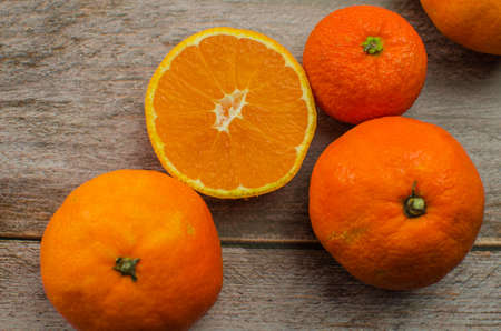 tangerines, peeled tangerine and tangerine slices on a white wooden tableの写真素材
