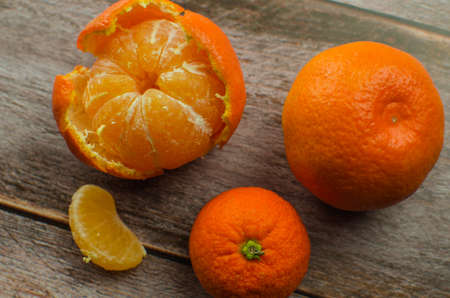 tangerines, peeled tangerine and tangerine slices on a white wooden table. copy spaceの写真素材