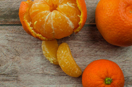tangerines, peeled tangerine and tangerine slices on a white wooden table. copy spaceの写真素材