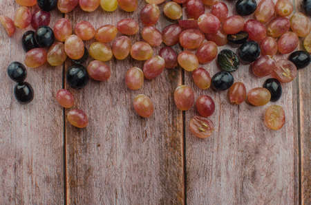 Blue grapes with green leaf healthy eating, isolated on wood background.の写真素材