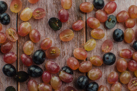 Blue grapes with green leaf healthy eating, isolated on wood background.の写真素材