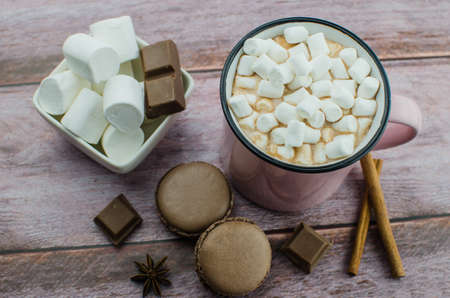 Cocoa drink with spices, zephyr and macaroons on wooden backgroundの写真素材