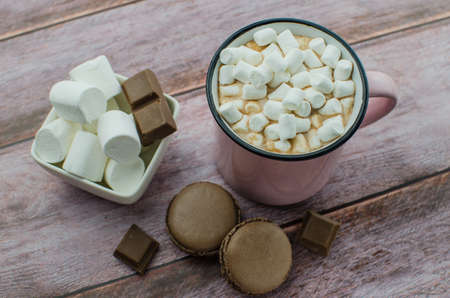 Cocoa drink with spices, zephyr and macaroons on wooden backgroundの写真素材