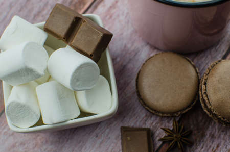 Cocoa drink with spices, zephyr and macaroons on wooden backgroundの写真素材