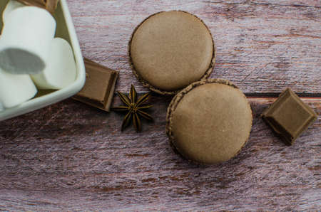 Cocoa drink with spices, zephyr and macaroons on wooden backgroundの写真素材
