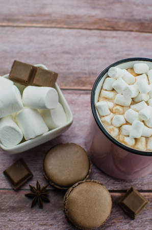 Cocoa drink with spices, zephyr and macaroons on wooden backgroundの写真素材