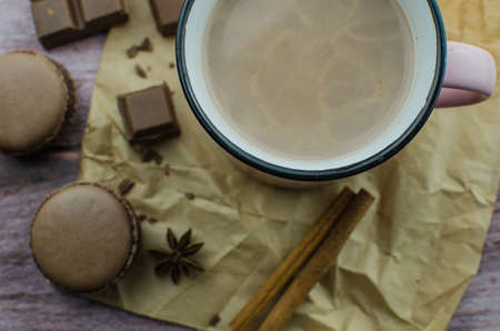 Cocoa drink with spices, zephyr and macaroons on wooden backgroundの写真素材