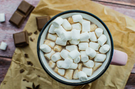 Cocoa drink with spices, zephyr and macaroons on wooden backgroundの写真素材