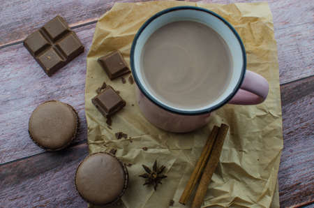 Cocoa drink with spices, zephyr and macaroons on wooden backgroundの写真素材