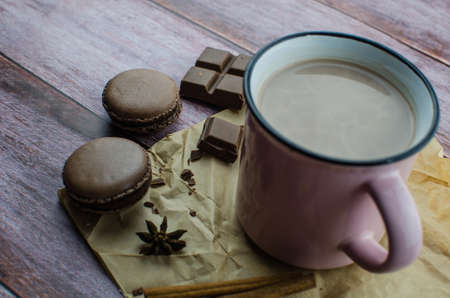 Cocoa drink with spices, zephyr and macaroons on wooden backgroundの写真素材