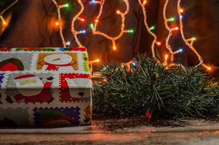Gift boxes with a large red bow against a background bokeh of twinkling party lights. Luxury New Year gift. Christmas gift. Christmas background with gift box. Christmastime celebration. Copy space to text.の写真素材