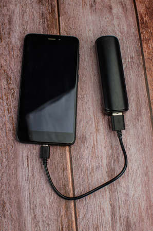 powerbank and cellphone on wooden table. Copy space for textの写真素材