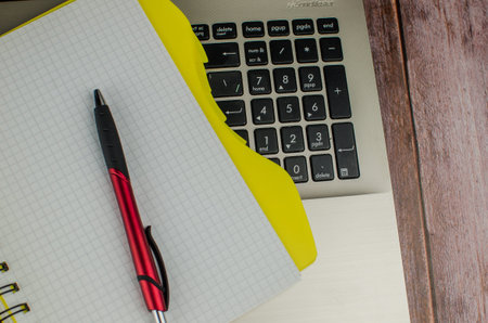 Pen and notebook on laptop. Copy space for text