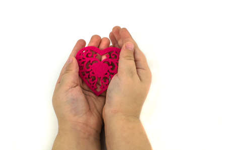 Child's hands with a red heartの写真素材