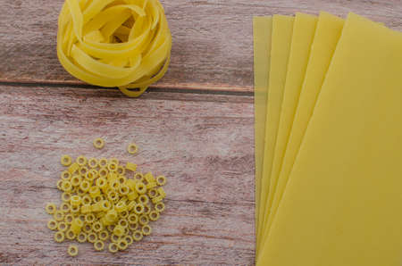 Choosing a meal of dried pasta on a wooden background. Copy space for textの写真素材