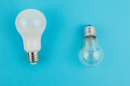 incandescent lamp and energy saving on a blue background. Copy space