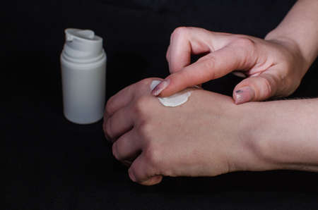 Smear cream on woman hand. Lotion for face or body.の写真素材