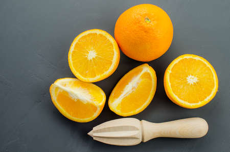 Orange juice and orang with a wooden orange juicer on a black backgroundの写真素材