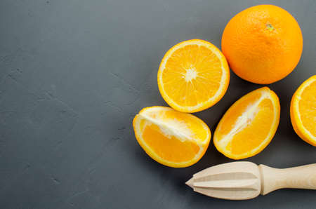 Orange juice and orang with a wooden orange juicer on a black backgroundの写真素材