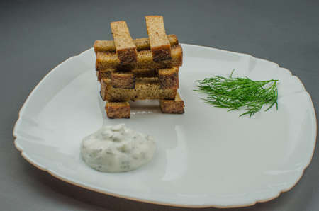 Toasts are fried on a frying pan with spices. Served on a white plate with garlic sauceの写真素材