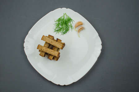Toasts are fried on a frying pan with spices. Served on a white plate with garlic sauceの写真素材