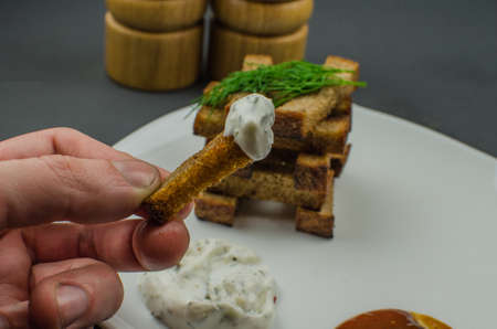 Toasts are fried on a frying pan with spices. Served on a white plate with garlic sauceの写真素材