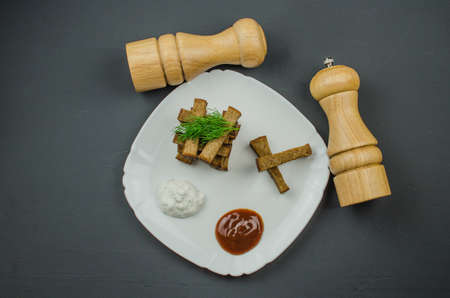Toasts are fried on a frying pan with spices. Served on a white plate with garlic sauceの写真素材