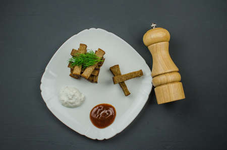 Toasts are fried on a frying pan with spices. Served on a white plate with garlic sauceの写真素材