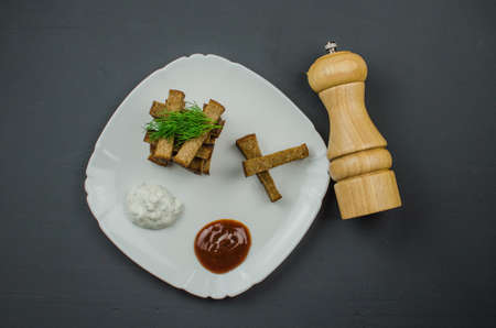 Toasts are fried on a frying pan with spices. Served on a white plate with garlic sauceの写真素材