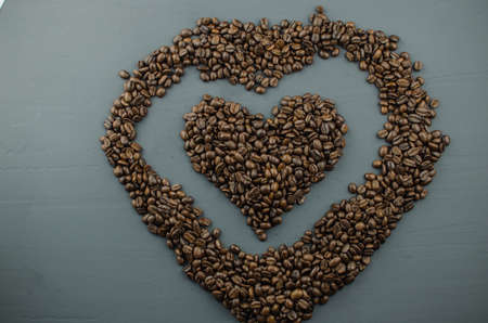 Turkish or Greek Coffee in heart shaped roasted coffee beans on white rustic wooden table from top view.の写真素材