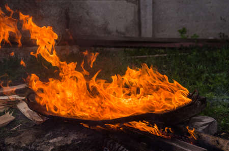Fried bbq potatoes in a large frying pan on an open fire with smoke. Cooking roasted for barbecue picnicの写真素材