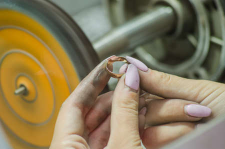 polishing a wedding ring. Jewelry production. Close upの写真素材