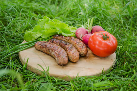 Grilled sausage and vegetables on old wooden background. Top view. Flat lay.の写真素材