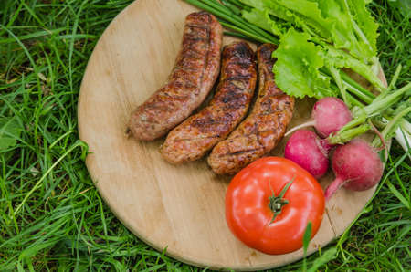 Grilled sausage and vegetables on old wooden background. Top view. Flat lay.の写真素材