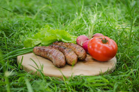 Grilled sausage and vegetables on old wooden background. Top view. Flat lay.の写真素材