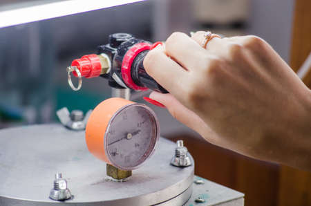 Jeweler working with wax model ring in his workshop.の写真素材