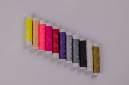 Multi-colored threads in spools, sewing kit, tailor's kit on a light background.の写真素材